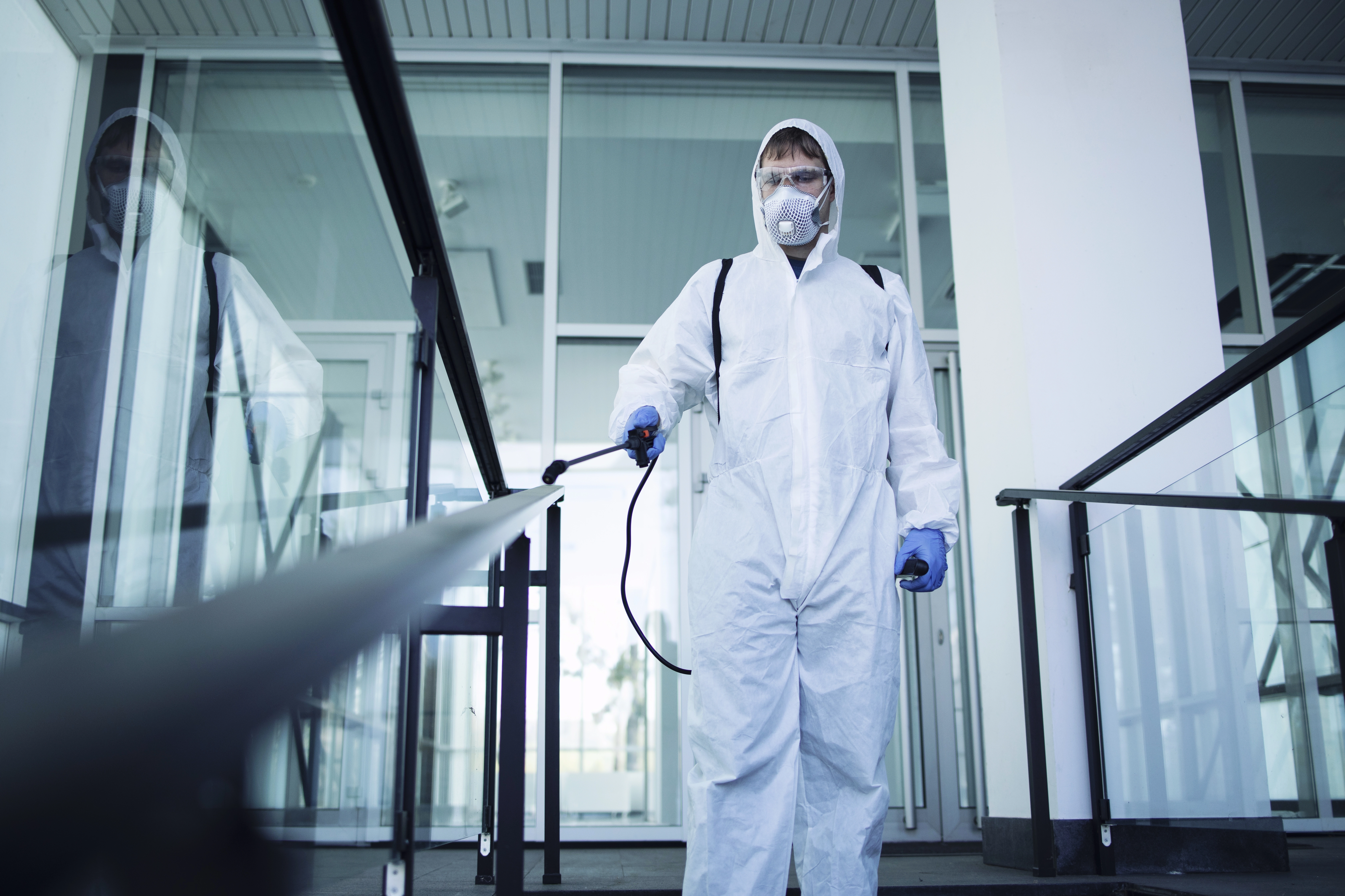 Técnico con equipo de protección realizando desinfección profesional de espacios públicos y oficinas en Medellín.